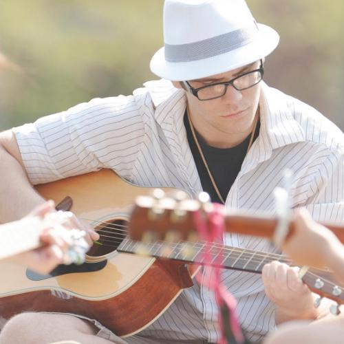 Students playing guitar in the courtyard